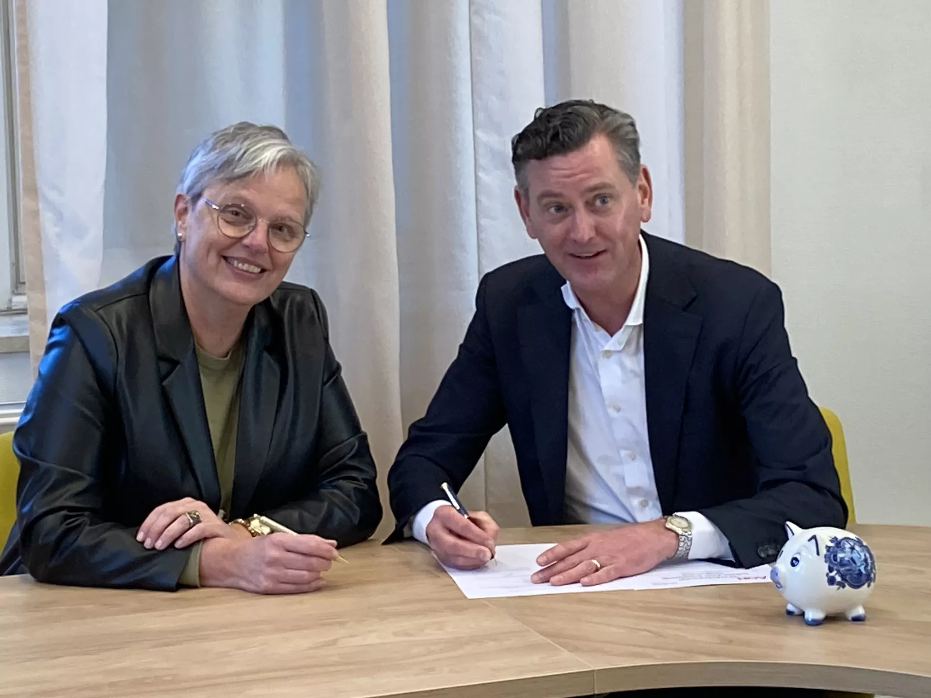 Beide directeuren tekenen de overeenkomst