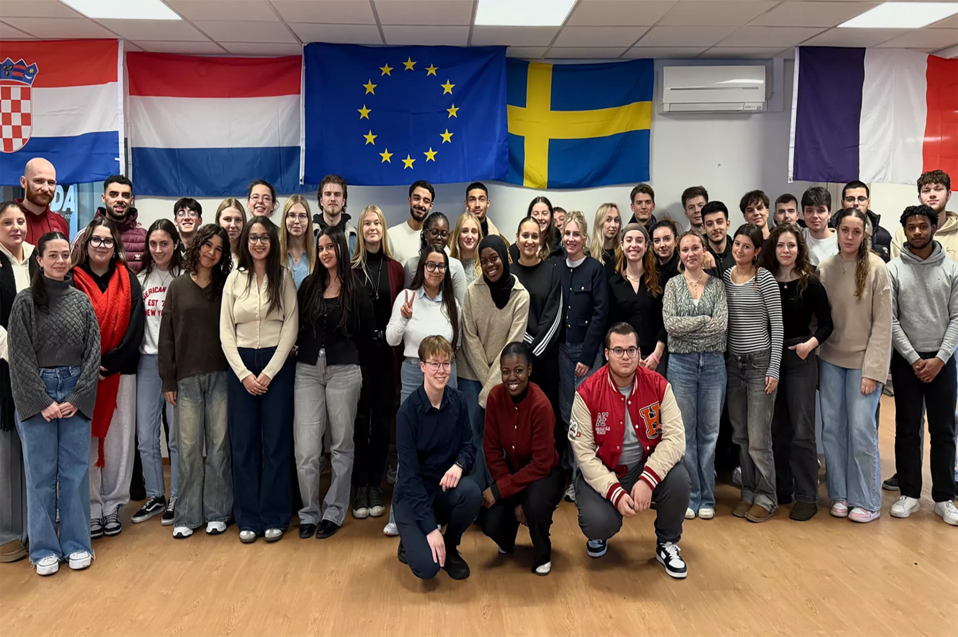 studenten poseren voor Europese vlaggen