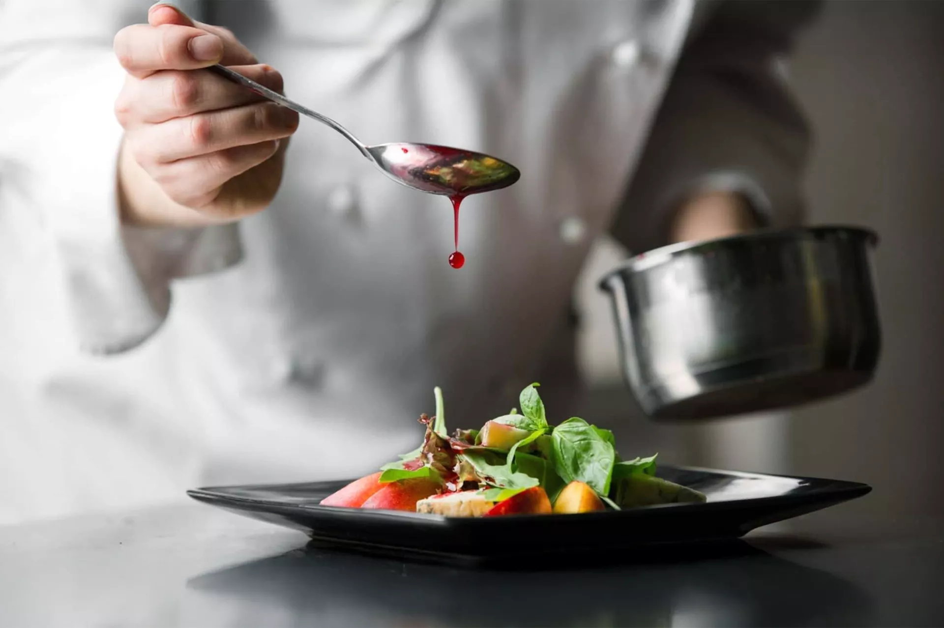 student van koksopleiding maakt bord op