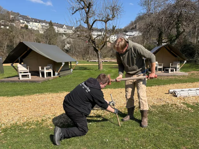 student en begeleider aan de slag op de camping