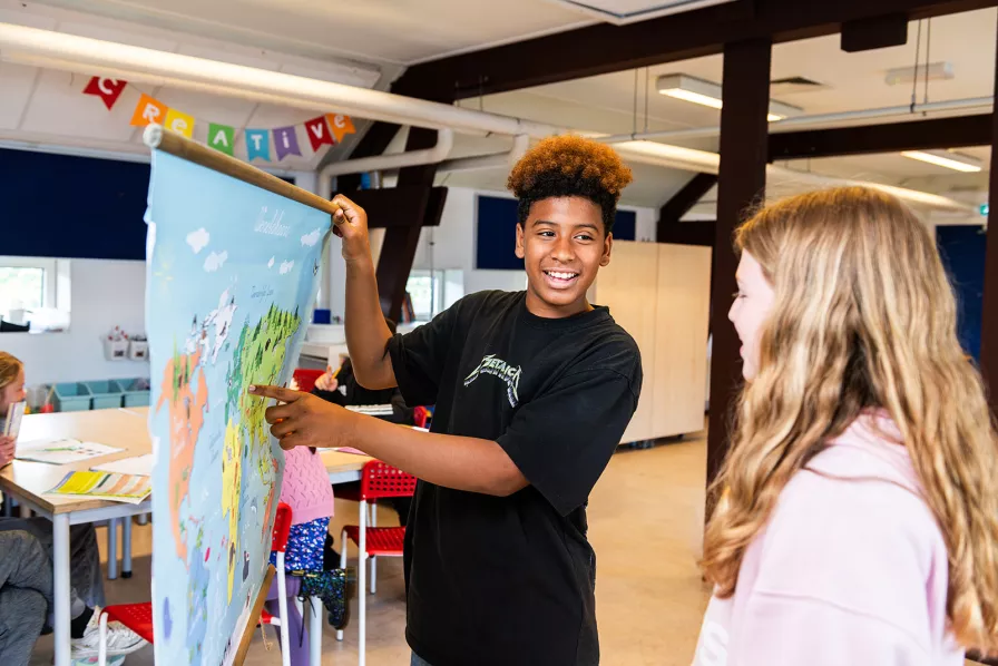 leerling houdt een wereldkaart omhoog