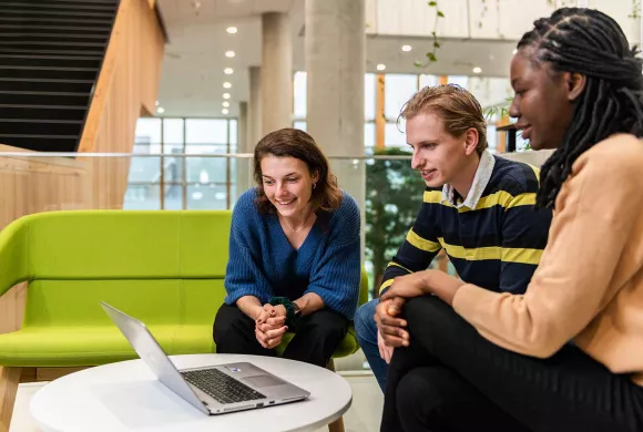 Studenten praten tijdens het kijken naar een laptop