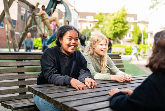 Leerlingen kletsen met elkaar op schoolplein