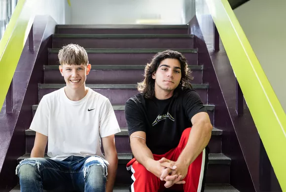 twee leerlingen van het Merletcollege poseren op de trap