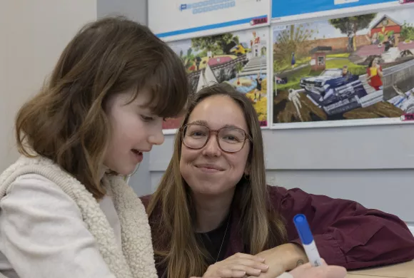Leerkracht geeft uitleg aan een leerling