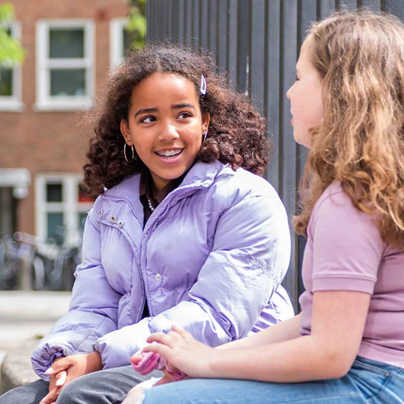 twee leerlingen praten met elkaar op het schoolplein