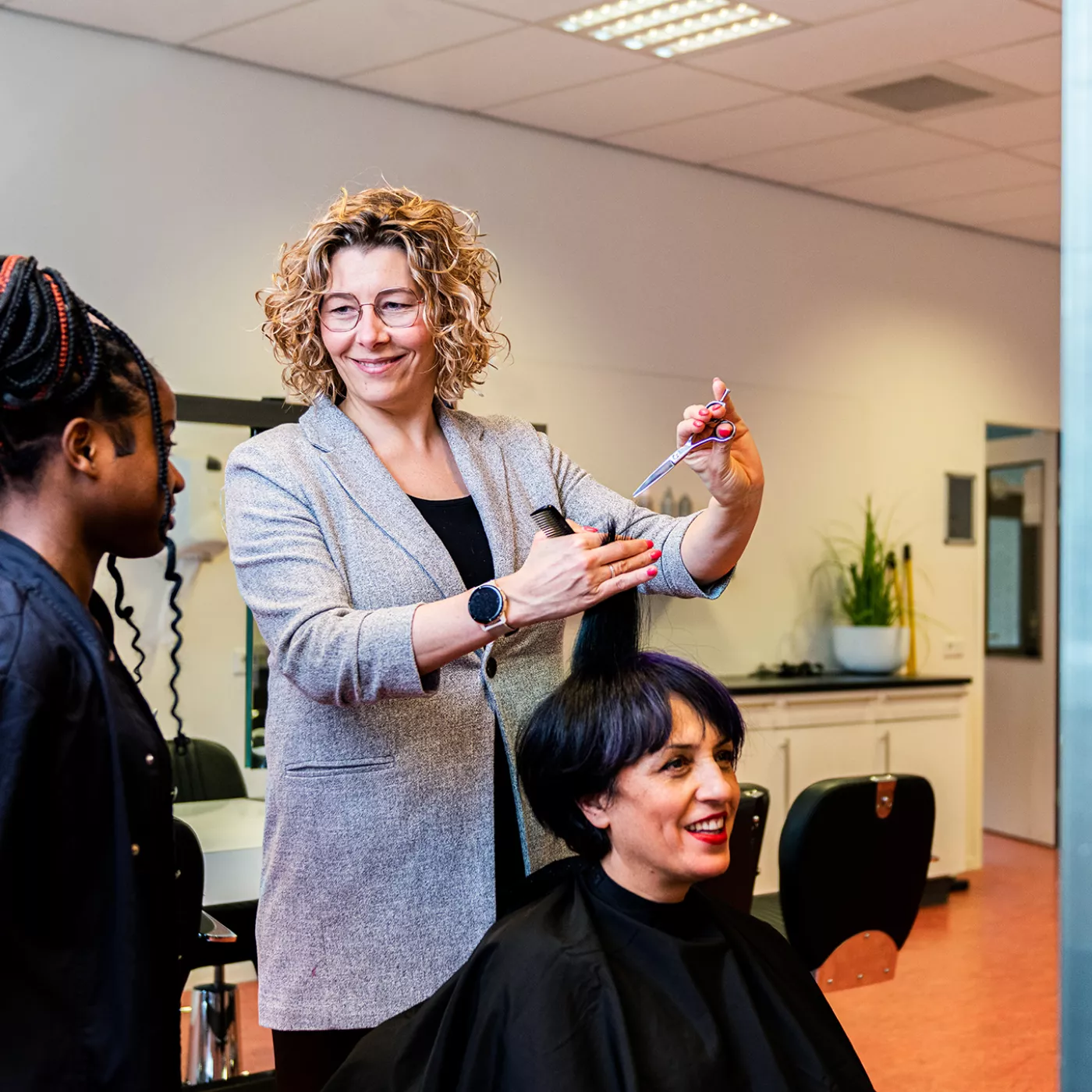 docent kappersopleiding Alfa college doet handeling voor bij student