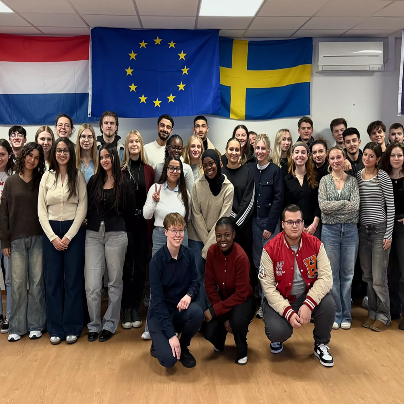 studenten poseren voor Europese vlaggen