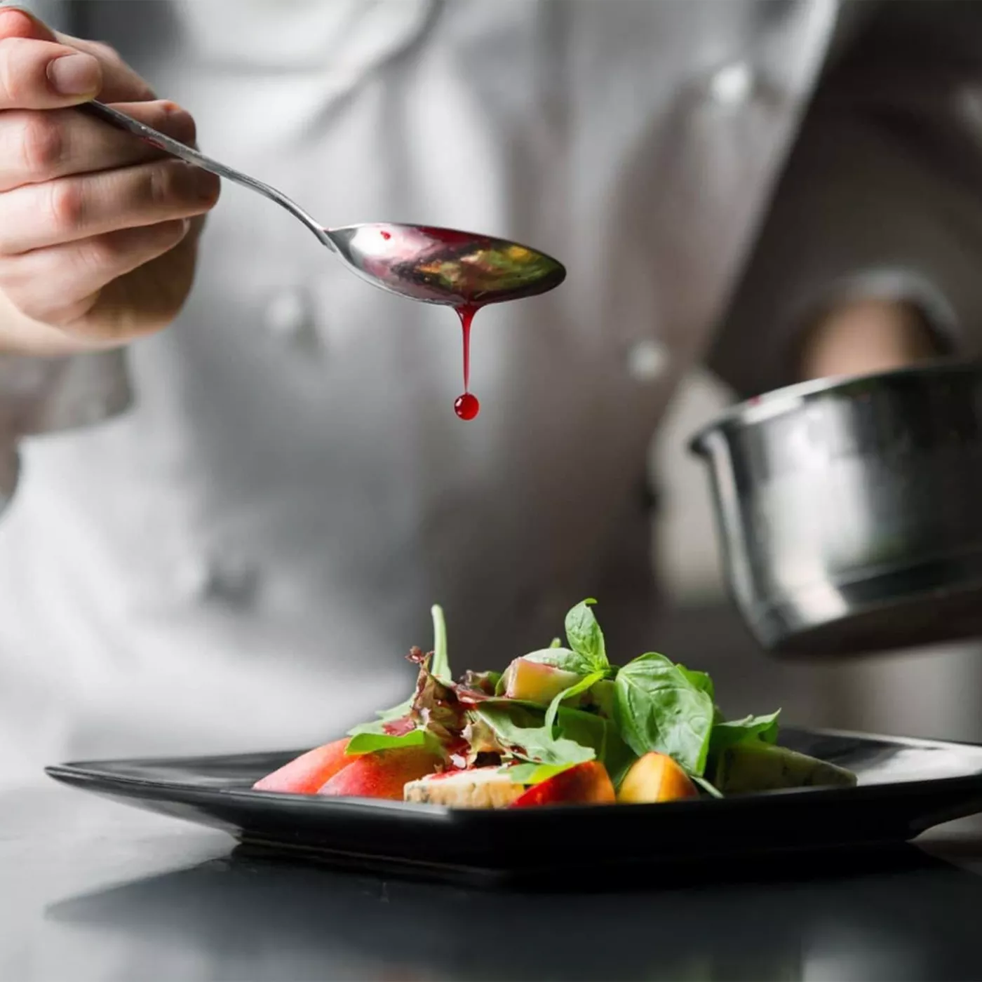 student van koksopleiding maakt bord op