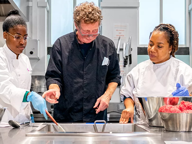 mbo-studenten krijgen uitleg van docent tijdens kookles
