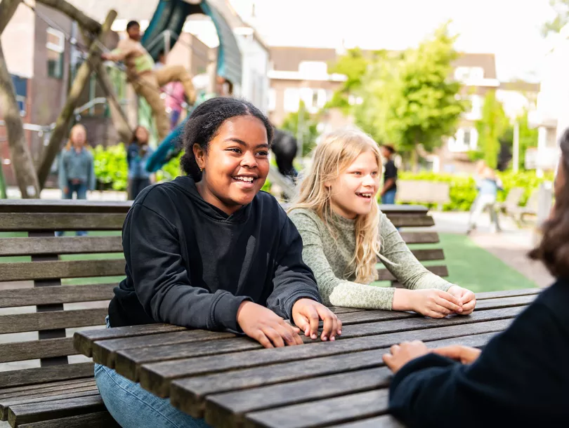 Leerlingen kletsen met elkaar op schoolplein