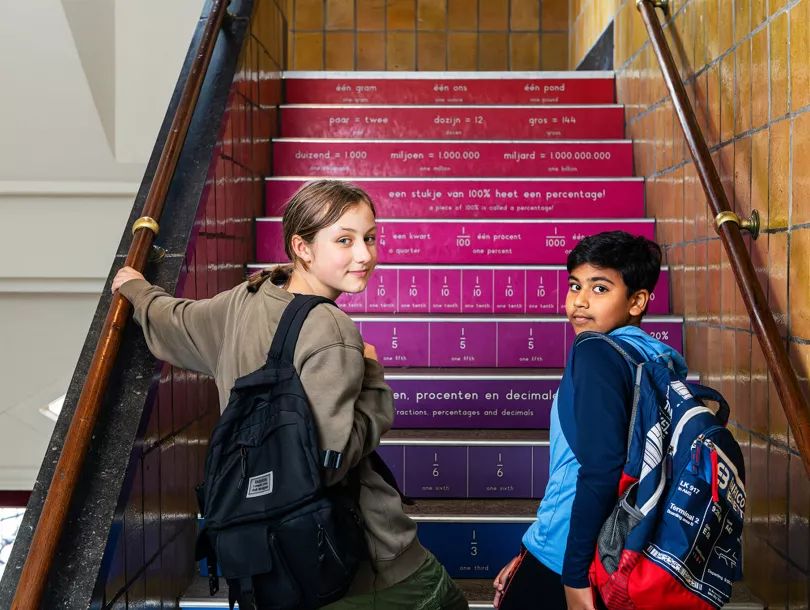 Twee basisschoolleerlingen lopen samen schooltrap op
