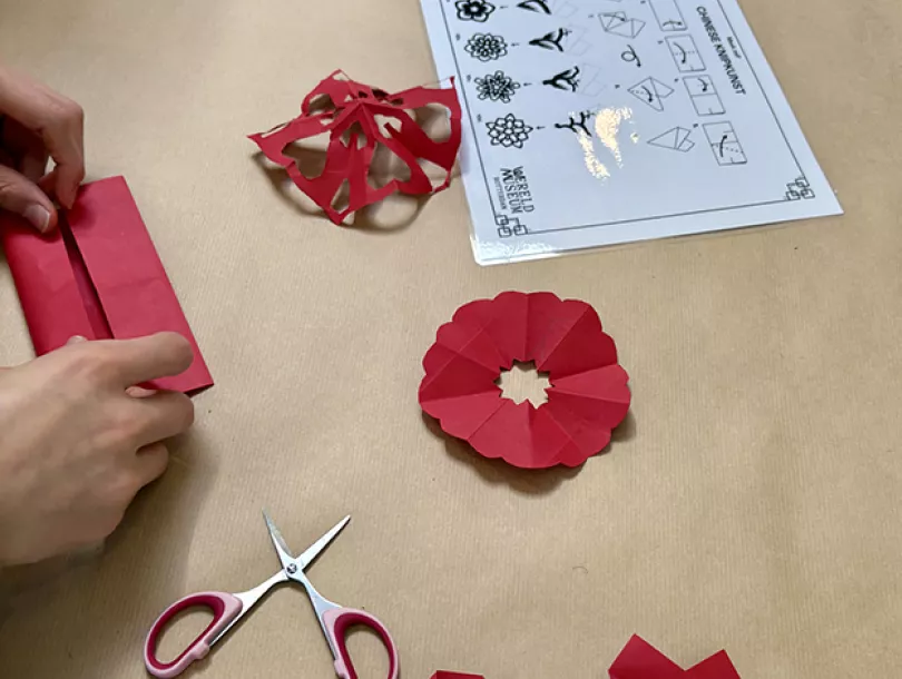 leerlingen knippen en vouwen tijdens een workshop Chinese papierkunst
