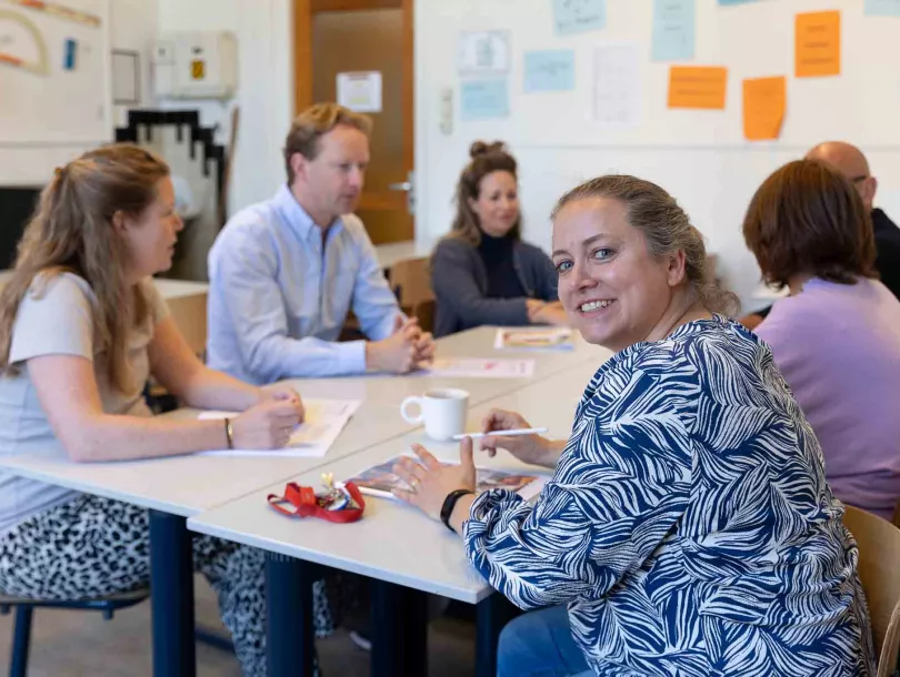 Groep docenten overlegt met elkaar