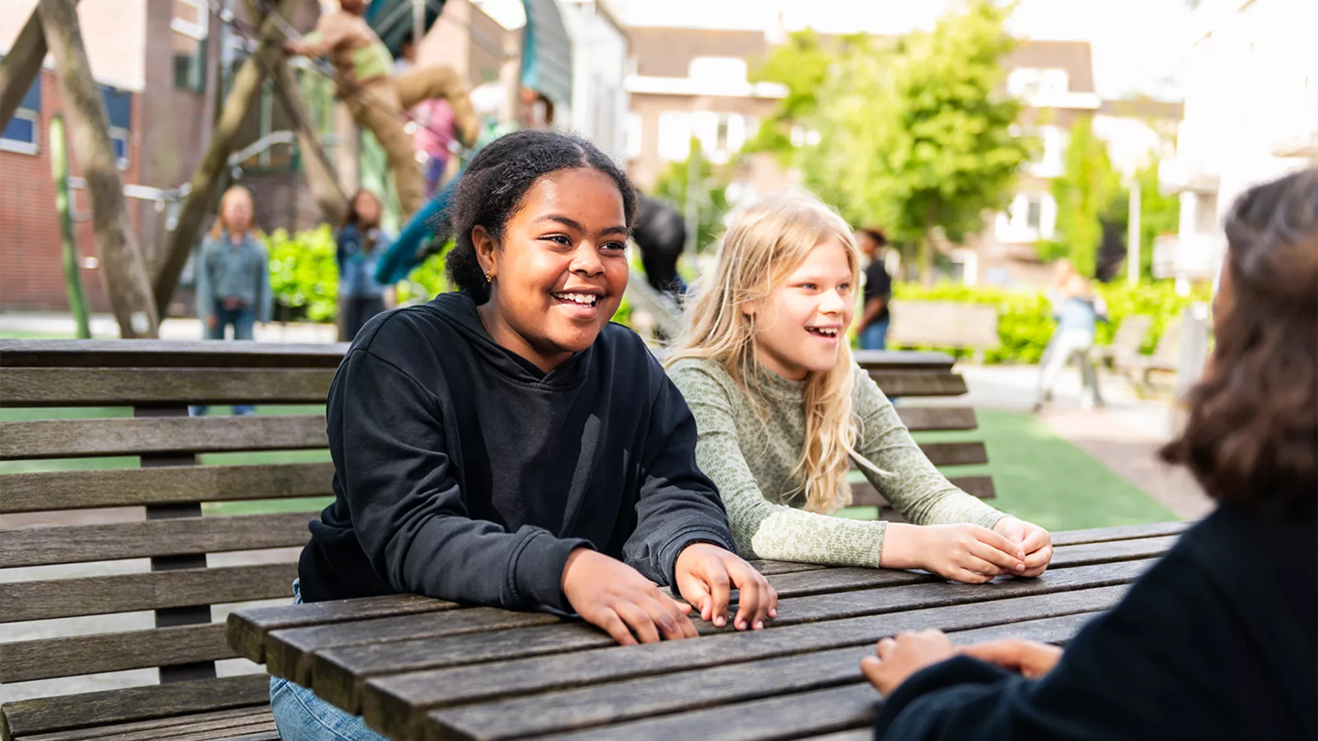 Leerlingen kletsen met elkaar op schoolplein