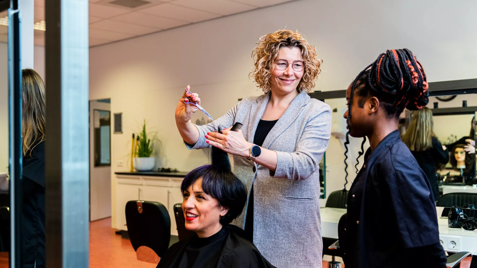 docent geeft instructie aan student kappersopleiding