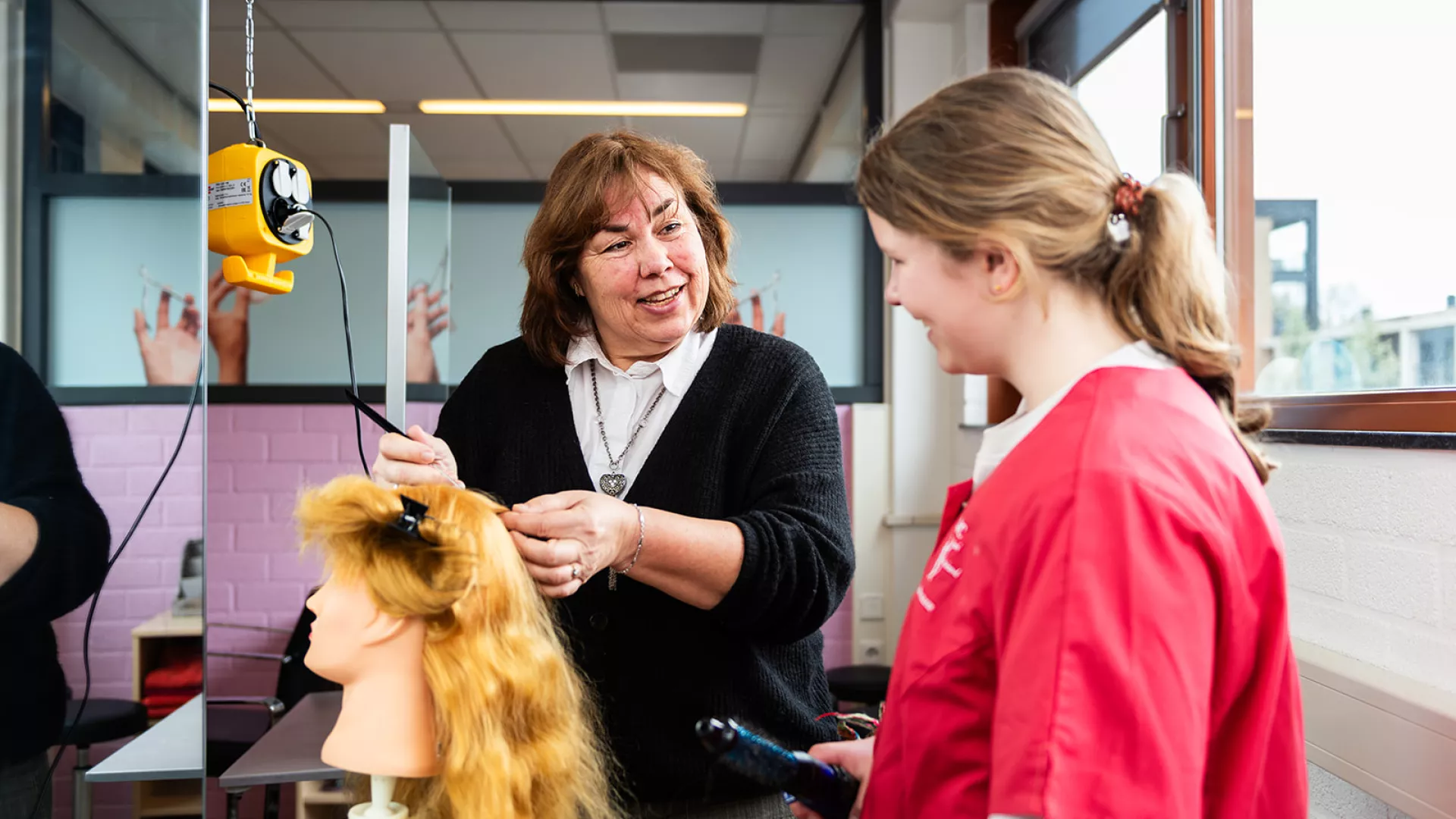 docent geeft instructie aan leerling vmbo
